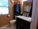 Clean bathroom with toilet, vanity, mirror, and cabinet space at 10229 W Bolivar Dr, Sun City, AZ 85351