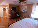 Cozy bedroom featuring a wooden bed frame, ceiling fan, and natural light at 10229 W Bolivar Dr, Sun City, AZ 85351