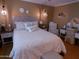 Bedroom with a plush bed, bedside tables, lamps, decorative pillows, and a charming vanity area at 10229 W Bolivar Dr, Sun City, AZ 85351