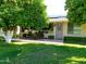 Charming home featuring a well-maintained lawn and patio area, shaded by mature citrus trees at 10229 W Bolivar Dr, Sun City, AZ 85351