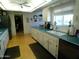 Bright kitchen featuring white cabinetry, turquoise countertops and wood flooring at 10229 W Bolivar Dr, Sun City, AZ 85351