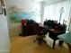 Bright office space with a large desk, chair, storage, and a beautiful tropical-themed mural on the wall at 10229 W Bolivar Dr, Sun City, AZ 85351