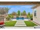 Lush backyard oasis with pool, waterfall feature, patio area, and vibrant greenery create a relaxing atmosphere at 10631 E Tallahassee Ave, Mesa, AZ 85212