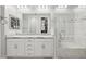 Bright bathroom features a large mirror, dual sinks, granite countertops, and a glass enclosed shower at 10631 E Tallahassee Ave, Mesa, AZ 85212