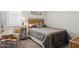 Cozy bedroom featuring carpet, a nightstand, and a wicker headboard with complementary colored bedding at 10631 E Tallahassee Ave, Mesa, AZ 85212