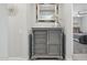 Stylish grey dresser with a decorative mirror and floral arrangement sits adjacent to a bedroom entrance at 10631 E Tallahassee Ave, Mesa, AZ 85212