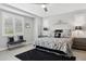 Bright main bedroom with large windows, plantation shutters, a ceiling fan, and stylish black and white accents at 10631 E Tallahassee Ave, Mesa, AZ 85212