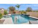 Sparkling pool with a waterfall feature, lush landscaping, and lounge area offers a luxurious outdoor experience at 10631 E Tallahassee Ave, Mesa, AZ 85212