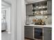 Well-stocked wet bar features sleek gray cabinets, a wine fridge, and mirrored backsplash for a touch of elegance at 10631 E Tallahassee Ave, Mesa, AZ 85212