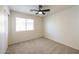 Bedroom featuring neutral carpet, ceiling fan, window, and a closet with sliding doors at 11357 W Buchanan St, Avondale, AZ 85323