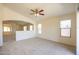 Spacious living area with neutral carpet, ceiling fan and connecting rooms at 11357 W Buchanan St, Avondale, AZ 85323