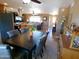 Open dining room with a dark wood table and seating, flowing into the kitchen and living area at 11415 N 110Th Dr, Sun City, AZ 85351