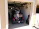A well-lit garage is home to a golf cart and golf clubs with additional storage on the back wall at 11415 N 110Th Dr, Sun City, AZ 85351