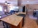 Modern kitchen with an island featuring a cooktop, stainless steel hood and countertop seating at 11415 N 110Th Dr, Sun City, AZ 85351