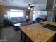 Open-concept living room with granite countertops and stainless steel appliances offering ample seating space at 11415 N 110Th Dr, Sun City, AZ 85351