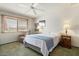 Cozy bedroom with plush carpeting, a ceiling fan, and ample natural light streaming through the window at 12542 W Parkwood Dr, Sun City West, AZ 85375