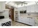 Well-organized kitchen featuring ample white cabinetry, modern appliances, wine rack, and convenient access to the dining area at 12542 W Parkwood Dr, Sun City West, AZ 85375