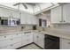 Practical kitchen design with white cabinets, black appliances, and a window offering a view to the outdoor patio area at 12542 W Parkwood Dr, Sun City West, AZ 85375
