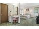 Bright main bedroom features an ensuite vanity area, ceiling fan, and plush carpet at 12542 W Parkwood Dr, Sun City West, AZ 85375