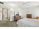 Bright main bedroom boasts an ensuite bath, ceiling fan, and large dresser at 12542 W Parkwood Dr, Sun City West, AZ 85375