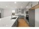 Bright kitchen featuring gray cabinets, quartz countertops, stainless steel appliances, tile backsplash, and hardwood floors at 13551 W Calle De Baca --, Peoria, AZ 85383