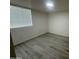 This bedroom features neutral walls, wood-look floors, and a window with blinds at 1524 E Cortez St, Phoenix, AZ 85020