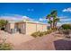Home showcasing a backyard with desert landscaping, mature palm trees, and an enclosed sunroom at 155 E Rodeo Rd # 64, Casa Grande, AZ 85122