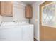 Functional laundry area equipped with a washer, dryer, and overhead cabinets for storage solutions at 155 E Rodeo Rd # 64, Casa Grande, AZ 85122