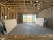 Unfinished living room with exposed beams ready for paint and flooring with sliding glass doors at 15788 W Beryl Ave, Waddell, AZ 85355