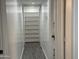 Hallway with white walls and multiple storage shelves at 1802 W Frier Dr, Phoenix, AZ 85021