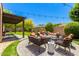 Landscaped backyard features artificial grass, brick flooring, outdoor furniture and pergola with string lights at 2011 W Calle De Las Estrella --, Phoenix, AZ 85085