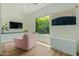 Modern living room showcasing a plush pink chair, television and floor to ceiling window at 2011 W Calle De Las Estrella --, Phoenix, AZ 85085