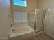 Bright bathroom with a soaking tub, glass shower, and natural light at 20275 N 81St Ln, Peoria, AZ 85382