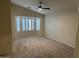 Bright carpeted bedroom with plantation shutters on bay window and a modern ceiling fan at 20275 N 81St Ln, Peoria, AZ 85382