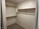 Bright walk-in closet with wood racks, offering ample storage and organization potential at 20275 N 81St Ln, Peoria, AZ 85382