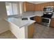 Bright kitchen with quartz countertops, wooden cabinets, and stainless steel appliances at 20275 N 81St Ln, Peoria, AZ 85382