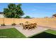 A cozy backyard space features a dining set on a brick patio, complemented by a well-manicured lawn and landscaping at 20834 W Prospector Way, Buckeye, AZ 85396