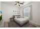 A bright bedroom featuring a comfortable bed, ceiling fan and stylish decor, with ample natural light through a window at 20834 W Prospector Way, Buckeye, AZ 85396