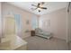 Cozy bedroom with pink walls, plush carpet, a ceiling fan, and bright windows for natural lighting at 20834 W Prospector Way, Buckeye, AZ 85396