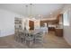 Open dining area with wood table, chandelier, and kitchen with breakfast bar at 20834 W Prospector Way, Buckeye, AZ 85396