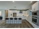 Bright kitchen boasts white cabinets, a large island with seating, and stainless steel appliances at 2121 W Sonoran Desert Dr # 43, Phoenix, AZ 85085
