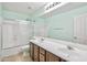 Bright bathroom featuring double sinks, tile flooring, and a tub and shower combination at 2323 W Hunter Ct, Phoenix, AZ 85085