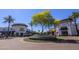 A vibrant shopping center with palm trees, shops, and a landscaped roundabout under a bright blue sky at 2323 W Hunter Ct, Phoenix, AZ 85085