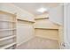 This walk-in closet is carpeted and features built-in shelving and hanging rods at 2323 W Hunter Ct, Phoenix, AZ 85085