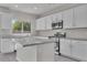 Well-lit kitchen featuring granite countertops, stainless steel appliances, a center island, and white cabinetry at 2512 N Pony Ln, Casa Grande, AZ 85122