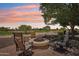 Charming backyard with firepit and comfortable seating overlooking a lush golf course and sunset at 27320 N 127Th Dr, Peoria, AZ 85383