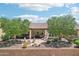 Expansive backyard featuring a covered patio, outdoor kitchen, fire pit, and desert landscaping at 27320 N 127Th Dr, Peoria, AZ 85383