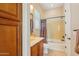 Well-lit bathroom with a tub, vanity, and convenient storage at 27320 N 127Th Dr, Peoria, AZ 85383