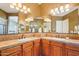 Bathroom featuring dual sinks, tile countertops, vanity lighting, and large mirrors at 27320 N 127Th Dr, Peoria, AZ 85383