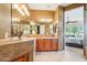 Bathroom features dual sinks, vanity, tile backsplash, decorative lighting, and access to the main bedroom at 27320 N 127Th Dr, Peoria, AZ 85383